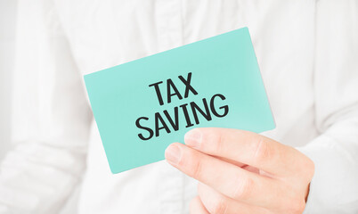 Businessman in white shirt holding a green card with text tax saving