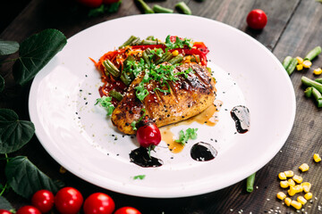 Chicken fillet baked with vegetables on a white plate