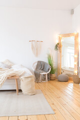 cute cozy light interior design of the apartment with a free layout of the kitchen and bedroom areas. a lot of windows, a wooden floor and a hanging swing.