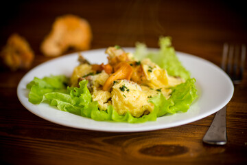 fried omelet with forest mushrooms chanterelles, on table