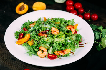 Salad with herbs and shrimps on a white plate