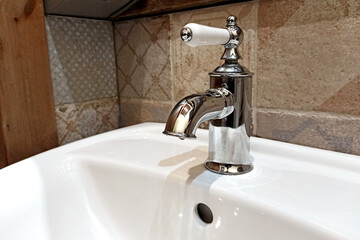 Modern sinks with a mirror in a public toilet. Bachelor's reflection in the mirrors.