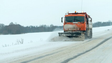 Winter. A special vehicle clears the road from snow.