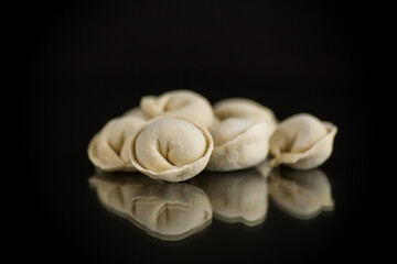 raw homemade dumplings with meat on black background