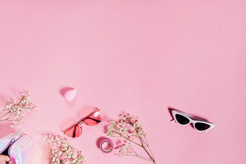 Photo of cute two pair of sunglasses on pink background with flowers