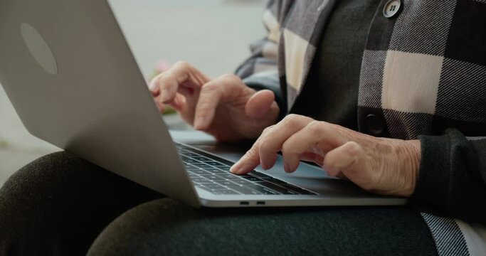 Close-up of female hands typing on laptop outdoors, freelance, extra income