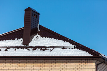 Snow on the roof of the house.