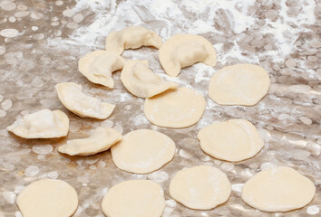 Modeling dumplings from dough on the table.