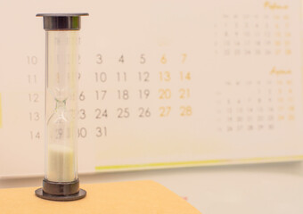 hourglass on the calendar background. The concept of time