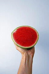Small seedless watermelon on hand in a bright background 