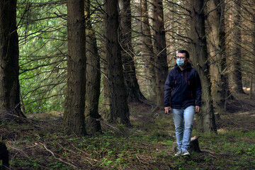 young man walks through the woods during the new normal