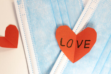 red heart on a mask on valentine's day on a white isolated background. heart surgical mask with place for inscription, mock up, copy space