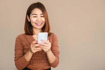beautiful Asian woman hand holding smart phone with happy face browsing internet , technology with people
