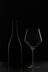 Bottle of wine and glass on black background