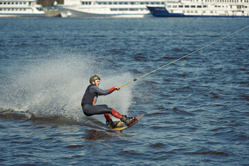 Young man riding wakeboard on a summer lake