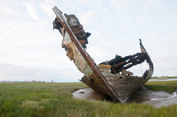 An old wooden shipwreck, showing signs of decay and deterioration. An old nautical sea vessel...