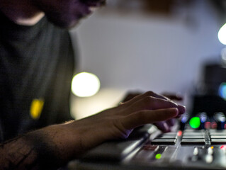Beatmaker producing some beats with a drum machine in his home studio