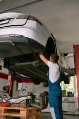 Mechanic repairing auto on car service station