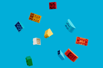 multicolored children's toys fly in the air on a blue background.phone screensaver