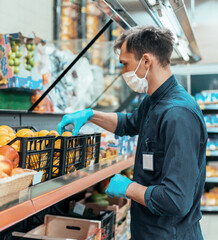 seller in a protective mask standing in front of the counter with fruit.