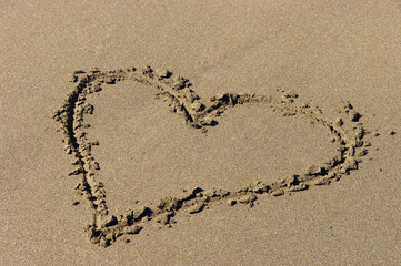 ein herz ist im sand am strand eingezeichnet