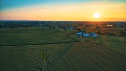 Aerial View of Multiple Farms and Pastures with Field of Corn Grows on Them at Sunset on a Beautiful Summer Day