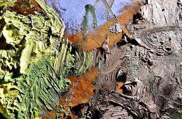 Brushstrokes of green, gray, brown artistic oil paint on the palette