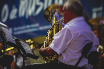 Concert view of an jazz orchestra tubist Tuba player performs with musical jazz band and audience...