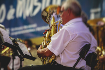 Concert view of an jazz orchestra tubist Tuba player performs with musical jazz band and audience...