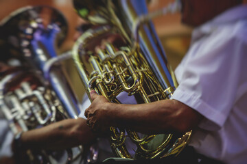 Concert view of an jazz orchestra tubist Tuba player performs with musical jazz band and audience in the background on open air concert