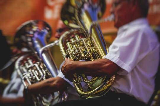 Concert view of an jazz orchestra tubist Tuba player performs with musical jazz band and audience in the background on open air concert