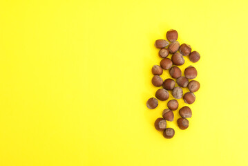 Handful of peanut nuts in shell on yellow background