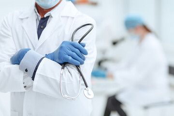 practicing doctor with a stethoscope in his hands on the background of the laboratory.