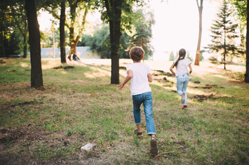 Fototapeta premium boy and girl running along the path in the forest