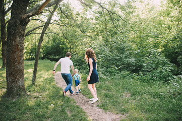 parents walk with their son in nature