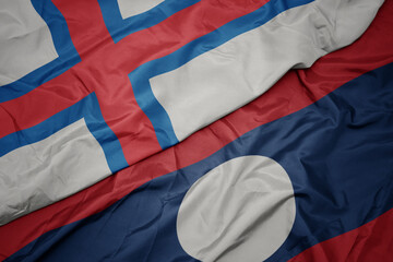 waving colorful flag of laos and national flag of faroe islands.