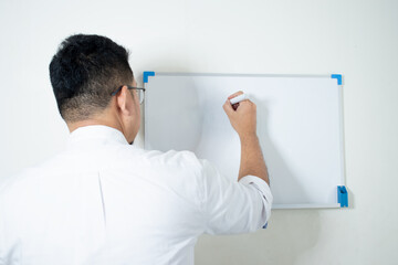 Fototapeta premium Businessman writing in a whiteboard