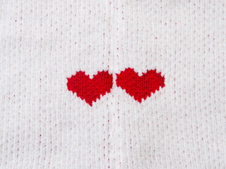Red heart shape on white fabric texture.