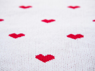 Red heart shape on white fabric texture.