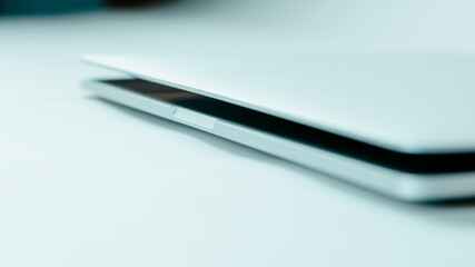 image of a slightly open laptop on a light background.