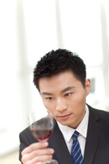 Portrait of businessman at desk with a glass of wine