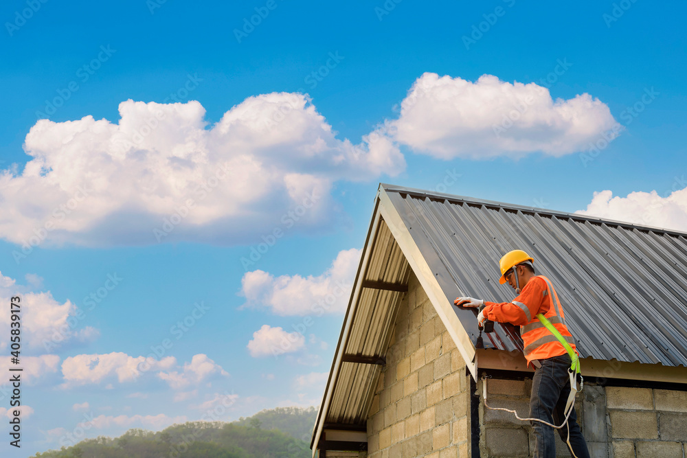 Wall mural roofer construction worker install new roof,roofing tools,electric drill used on new roofs with meta