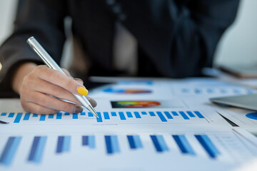 Financial Businesswomen analyze the graph of the company's performance to create profits and...
