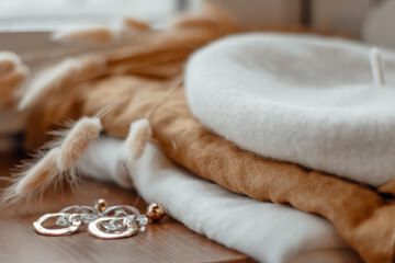 Naklejka premium Beret and scarf on the table, also earrings and a glass of coffee