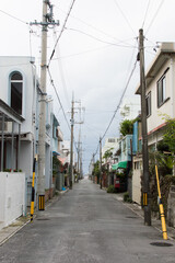 Fototapeta na wymiar 日本の電柱が並ぶ路地裏の直線の道