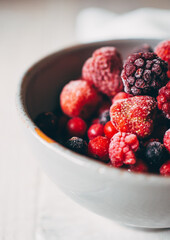 close up of red frozen fruits in bowl