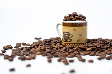 Roasted coffee beans in the ceramic cup isolated over white background.