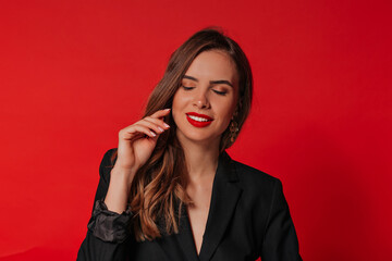 Smiling tenderness woman with red lips and light-brown hair posing over red background and celebrating Valentines day