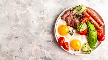 English breakfast. Fried egg, sausage, bacon, avocado, beans and toast on white background Top view, overhead, banner