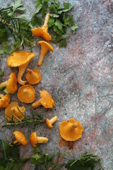 small mushrooms, yellow chanterelles stacked on the counter, parsley scattered about, fresh mushrooms